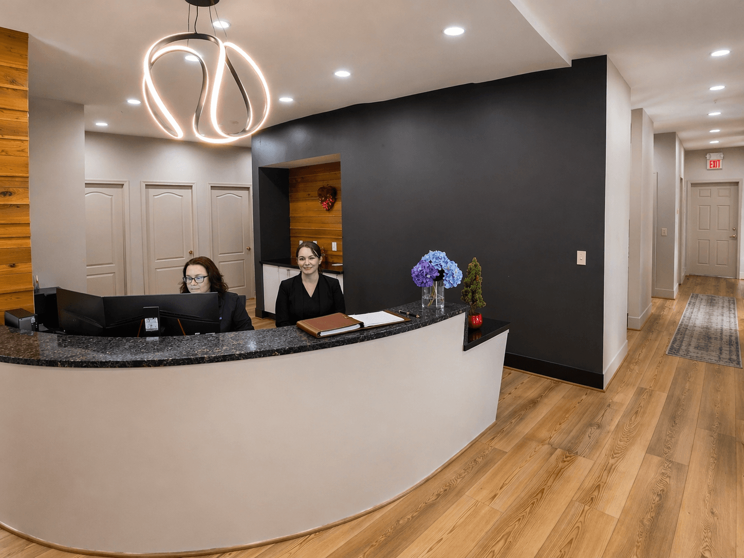 Bridgewater Dental Center front desk team welcoming patients beneath a modern ring chandelier